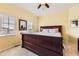 Bedroom with a large wooden sleigh bed, two windows, and neutral carpeting throughout at 9519 Pearl Cir # 105, Parker, CO 80134