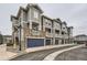 View of townhomes with attached garages, stone accents, and private balconies on each unit at 9519 Pearl Cir # 105, Parker, CO 80134