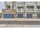 Townhome garages with stone accents, clearly marked unit numbers, and a well-maintained street at 9519 Pearl Cir # 105, Parker, CO 80134