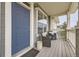 Inviting front porch with cozy seating and stylish blue door at 9519 Pearl Cir # 105, Parker, CO 80134