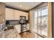 Stylish kitchen with stainless steel appliances and sliding glass door to balcony at 9519 Pearl Cir # 105, Parker, CO 80134