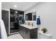 Modern bathroom featuring a double vanity, backlit mirror, and a sleek black tiled shower at 1900 E Girard Pl # 505, Englewood, CO 80113