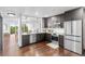 Modern kitchen with stainless steel appliances, dark wood cabinets, and open view to the dining area at 1900 E Girard Pl # 505, Englewood, CO 80113