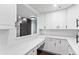 Bright, minimalist kitchen with white cabinetry, stylish backsplash, and sleek countertops at 1900 E Girard Pl # 505, Englewood, CO 80113