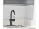 Stylish wet bar area featuring a sleek black faucet, sink, and modern countertops at 1900 E Girard Pl # 505, Englewood, CO 80113