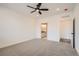 A bright bedroom with a ceiling fan and carpeted floors, featuring a doorway to an ensuite bathroom at 2484 W 69Th Pl, Denver, CO 80221