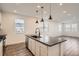 Modern kitchen featuring a center island with a sink, pendant lighting, and open layout to the dining area at 2484 W 69Th Pl, Denver, CO 80221