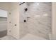 A tiled shower with a black shower head and a built in shelf at 2484 W 69Th Pl, Denver, CO 80221