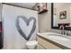 The bathroom includes a white heart shower curtain, black framed mirror, and vanity at 4063 S Quintero Way, Aurora, CO 80013