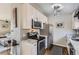 Updated kitchen featuring stainless steel appliances, white cabinetry, and modern lighting at 4063 S Quintero Way, Aurora, CO 80013