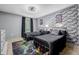 Bedroom with brick accent wall, fan, and a vibrant gaming rug at 16051 E Alabama Dr, Aurora, CO 80017