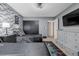 Bedroom with decorative brick wall, black sliding closet doors, and grey furnishings at 16051 E Alabama Dr, Aurora, CO 80017