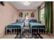 Charming bedroom featuring two beds, a butterfly rug, and pink walls at 16051 E Alabama Dr, Aurora, CO 80017