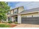Two-story home boasts a white brick facade, green siding, black shutters, and an attached garage at 16051 E Alabama Dr, Aurora, CO 80017