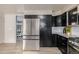 Kitchen featuring stainless steel refrigerator and appliances, and dark cabinetry with granite countertops at 16051 E Alabama Dr, Aurora, CO 80017