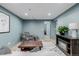 A living room with a comfortable armchair, wooden table, and fireplace, with light-blue painted walls at 16051 E Alabama Dr, Aurora, CO 80017