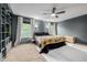 Cozy bedroom featuring green paneled walls, ceiling fan, and large windows with natural light at 16051 E Alabama Dr, Aurora, CO 80017