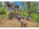 Outdoor seating area with six chairs around a fire pit with woodpile in view at 30273 Conifer Rd, Evergreen, CO 80439