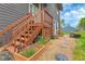 Landscaped backyard with stairs leading to an entrance and stone pathway surrounded by garden beds at 30273 Conifer Rd, Evergreen, CO 80439