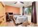 Inviting bedroom featuring a large bed, desk area, hardwood floors, and a bright window at 30273 Conifer Rd, Evergreen, CO 80439
