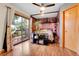 Cozy bedroom with a sliding glass door leading to a deck, hardwood floors, and built-in shelving at 30273 Conifer Rd, Evergreen, CO 80439