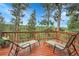 Relaxing deck area with outdoor furniture and scenic views of surrounding trees and landscape at 30273 Conifer Rd, Evergreen, CO 80439