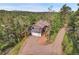 Charming exterior shot of home with attached garage nestled amongst beautiful trees and surrounding landscape at 30273 Conifer Rd, Evergreen, CO 80439