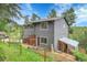 Exterior view of a gray home with a garden, green grass and a shed at 30273 Conifer Rd, Evergreen, CO 80439