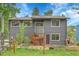 Exterior view of home showcasing garden boxes, front yard, and covered entryway at 30273 Conifer Rd, Evergreen, CO 80439