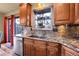 Kitchen featuring stainless steel dishwasher, granite countertops, and wood cabinetry at 30273 Conifer Rd, Evergreen, CO 80439