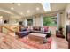 Bright living room with hardwood floors, large windows, and comfortable leather sectional at 30273 Conifer Rd, Evergreen, CO 80439