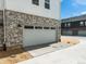 Attached two-car garage with durable concrete driveway and stylish stone veneer at 6531 N Malaya St, Aurora, CO 80019