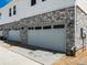 Attached two-car garage with a stone veneer and white siding, providing secure parking and curb appeal at 6531 N Malaya St, Aurora, CO 80019