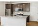 Close up of the kitchen featuring granite countertops, stainless steel appliances, and dark wood cabinets at 6531 N Malaya St, Aurora, CO 80019