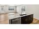 Kitchen island with stainless dishwasher, granite countertop, sink and dark wood cabinets at 6531 N Malaya St, Aurora, CO 80019