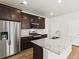 Well-equipped kitchen with stainless steel appliances, granite counters, dark cabinetry and kitchen island at 6531 N Malaya St, Aurora, CO 80019