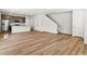 Spacious living room with wood-look floors open to the modern kitchen and staircase at 6531 N Malaya St, Aurora, CO 80019