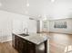 Open concept living area showcases kitchen island, recessed lights, wood-look floors and abundant natural light at 6531 N Malaya St, Aurora, CO 80019