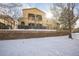 Back exterior view of a two-story house with a snow covered yard at 10587 Parkington Ln # B, Highlands Ranch, CO 80126