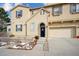 Tan two-story home with a two-car garage and landscaping at 10587 Parkington Ln # B, Highlands Ranch, CO 80126