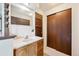 Clean bathroom with a vanity, neutral finishes, wood cabinetry, and ample storage space with sliding door closet at 8552 Gray Ct, Arvada, CO 80003