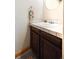Cozy powder room with vanity, dark wood cabinetry, tile countertop, and decorative fixtures at 8552 Gray Ct, Arvada, CO 80003