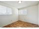 Comfortable bedroom with laminate flooring, two bright windows, and fresh white walls providing ample natural light at 8552 Gray Ct, Arvada, CO 80003