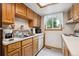 Functional kitchen with wooden cabinets, white appliances, and a bright window offering natural light at 8552 Gray Ct, Arvada, CO 80003