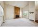 Spacious living room featuring a classic brick fireplace, bright natural light, and neutral carpeting throughout at 8552 Gray Ct, Arvada, CO 80003