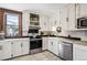 Bright kitchen featuring white cabinets, black backsplash, and stainless steel appliances at 1401 N Franklin St # 1, Denver, CO 80218