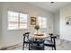 Bright dining area features modern decor, a round table, and natural light from the two windows at 2642 Devonshire Ct, Denver, CO 80229