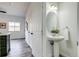 This powder room features a pedestal sink and is conveniently located near the kitchen and entryway at 2642 Devonshire Ct, Denver, CO 80229