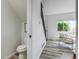 Bright hallway leading to a half bathroom and living room, next to the home's staircase at 2642 Devonshire Ct, Denver, CO 80229