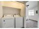 Convenient laundry area with washer and dryer; bedroom visible with natural light and neutral carpet at 2642 Devonshire Ct, Denver, CO 80229